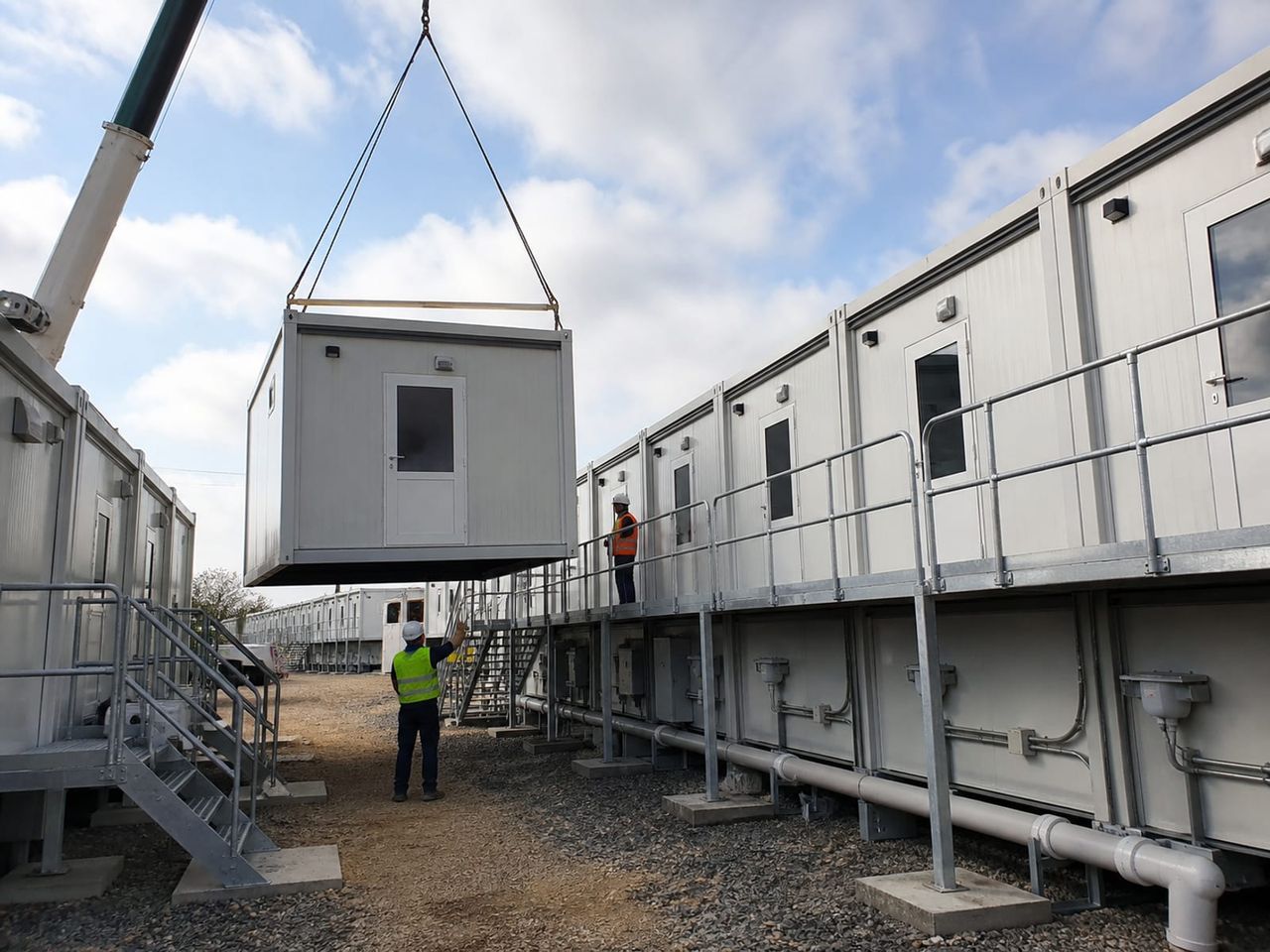 Dormitory container camp installation with crane placement, walkways, and utility connections