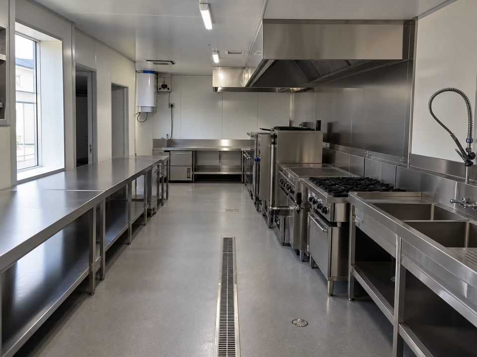 Prefab commercial kitchen with cooking line, extraction canopy, and hygiene finishes
