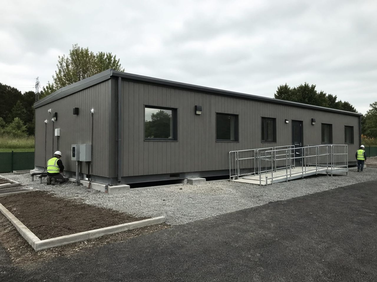 Custom container building installation with combined units, cladding, and external works