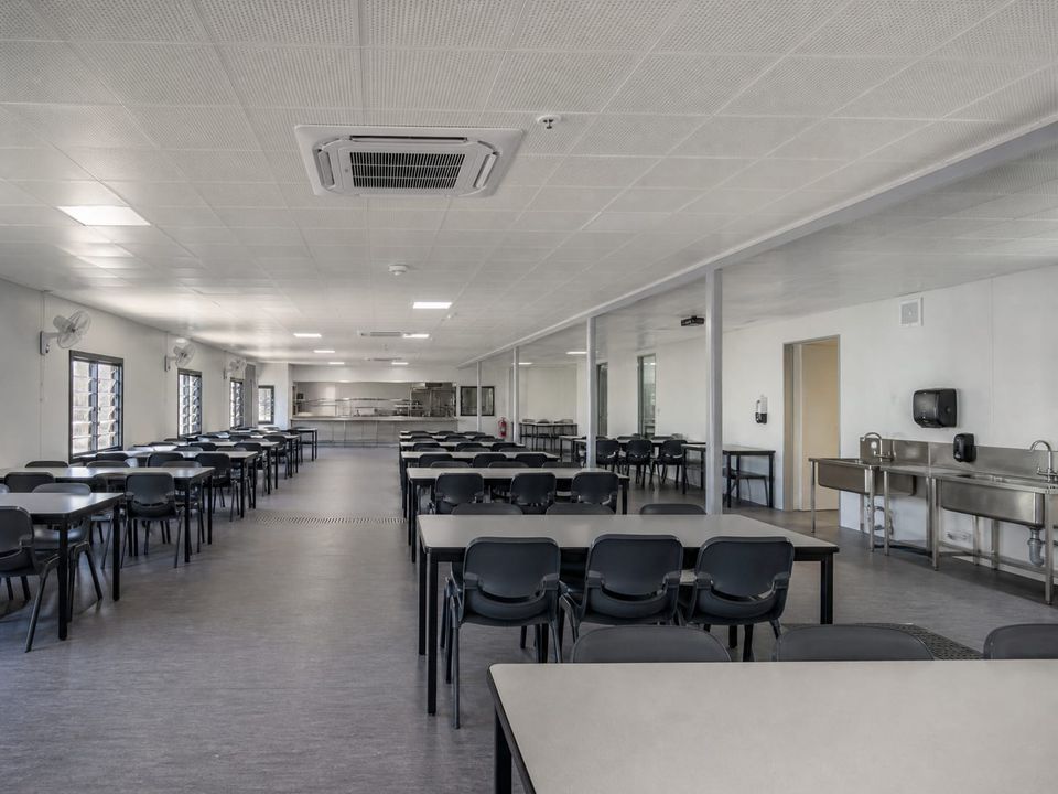 Prefab cafeteria dining hall with seating layout, circulation width, and acoustic treatment