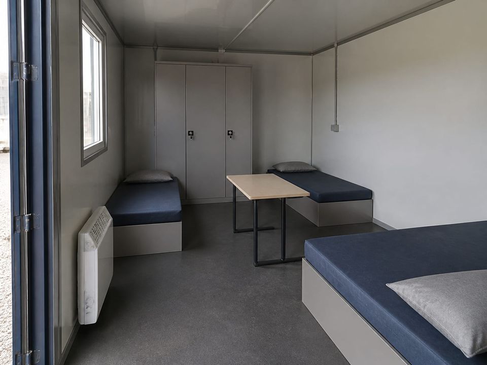 Disaster shelter container family unit with sleeping space, storage, and heating