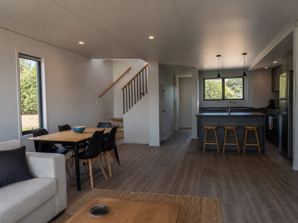 Two-storey prefab home ground floor living and dining with stair beyond