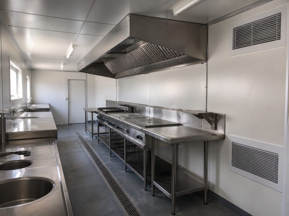 Cafeteria container kitchen with cooking line, extraction canopy, and hygiene finishes