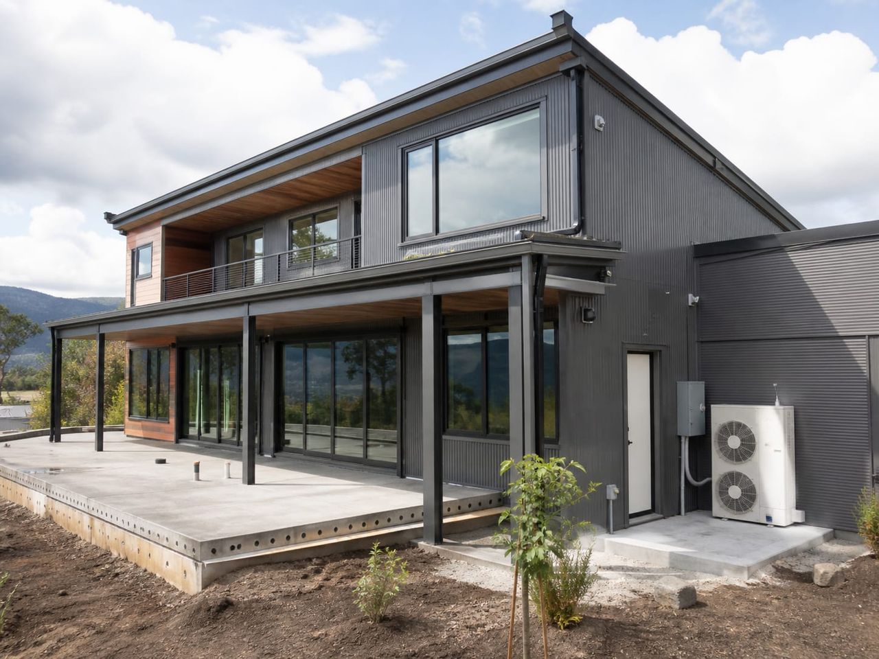 Premium steel home nearing completion with glazing installed and landscaping under way