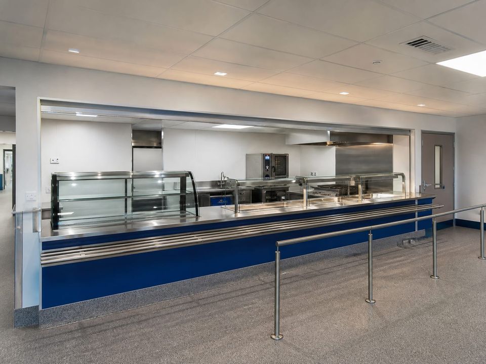 Prefab cafeteria servery counter arranged for tray flow and queue management