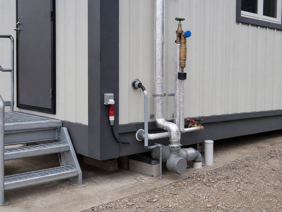 Sanitary container service connections brought outside the unit for mains hookup