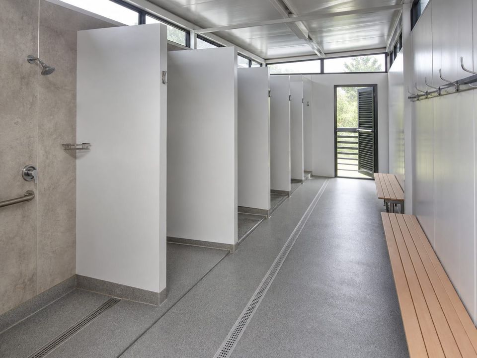 Prefab shower area with screening, benches, non-slip surfaces, and controlled drainage