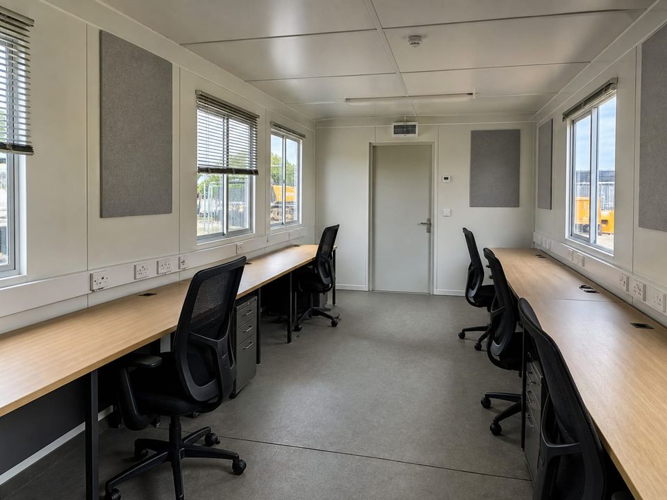 Container site office interior with desk positions, power and data provision, and daylight